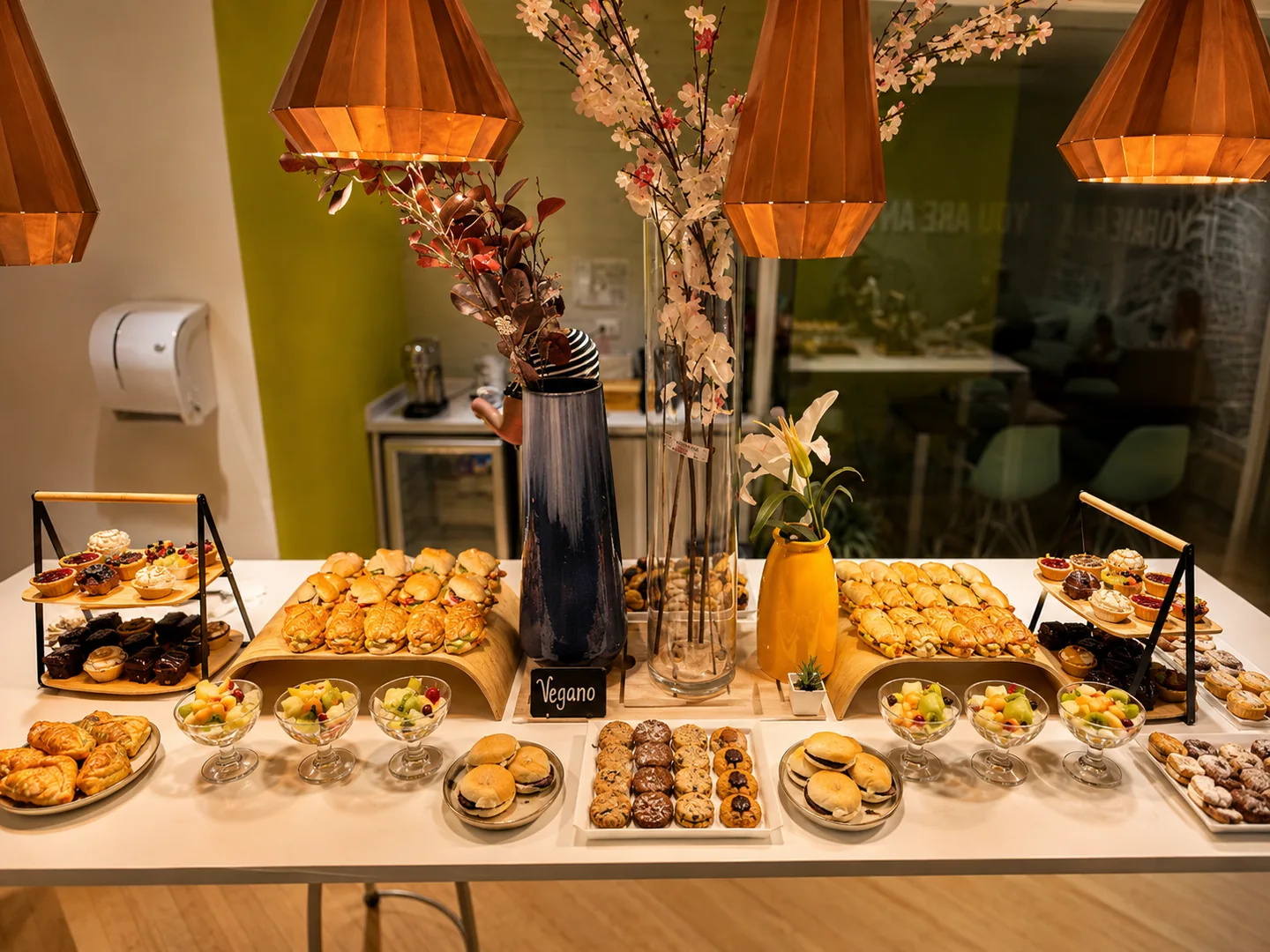 Mesa de coffee break con mini sándwiches, croissants, tartaletas y fruta en Viasanto