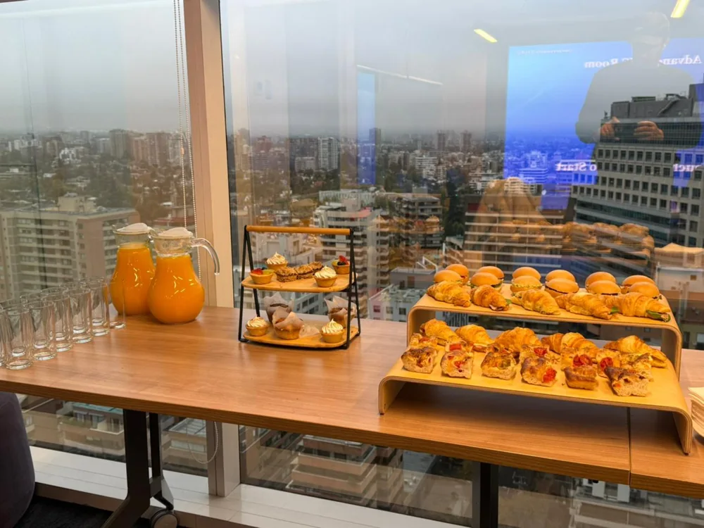 Montaje de coffee break en una oficina, con jugos, dulces y bocados salados
